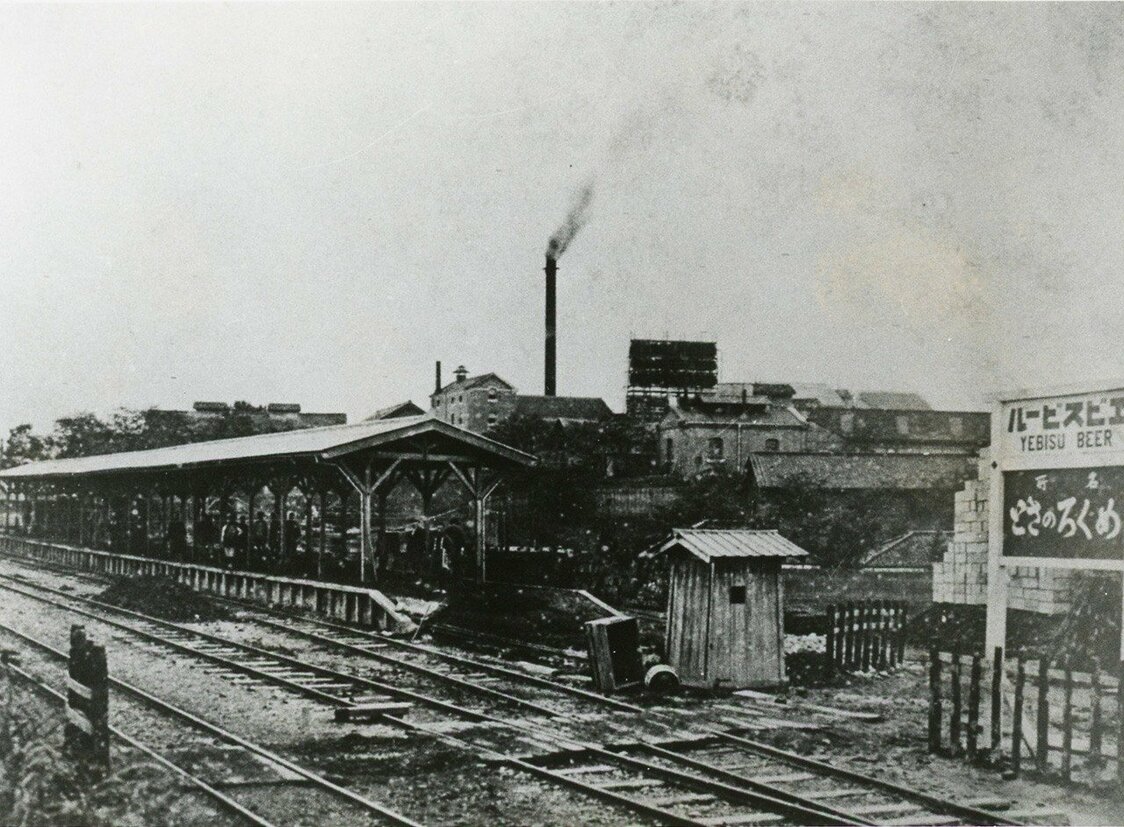 El andén y las vías de Ebisu en 1906, cuando se empezó a usar para el transporte de pasajeros. Al fondo se ve la chimenea de la fábrica de cerveza. Imagen cortesía del Ayuntamiento de Shibuya.