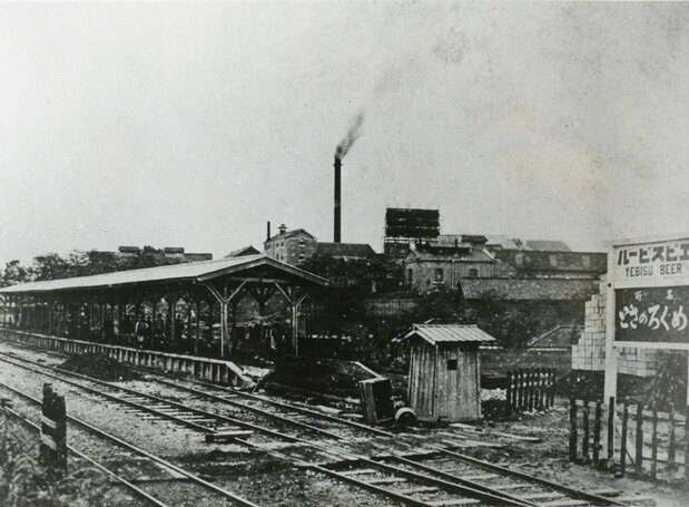 El andén y las vías de Ebisu en 1906, cuando se empezó a usar para el transporte de pasajeros. Al fondo se ve la chimenea de la fábrica de cerveza. Imagen cortesía del Ayuntamiento de Shibuya.