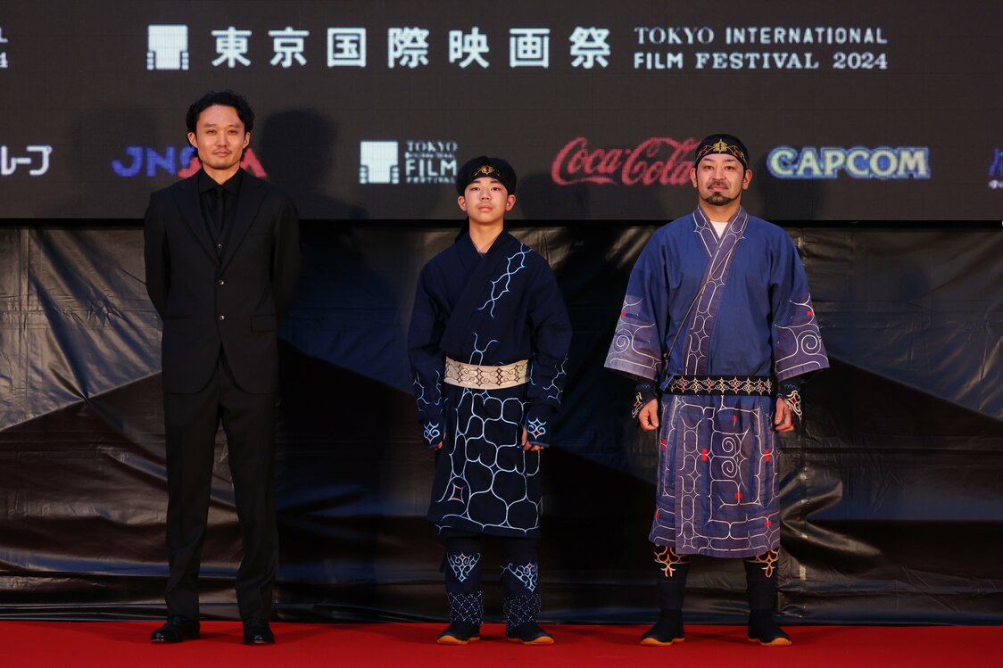 El director de Ainu puri, Fukunaga Takeshi (izquierda), con los actores Amanai Shigeki (derecha) y Amanai Motoki en la alfombra roja del Festival Internacional de Cine de Tokio el 28 de octubre de 2024. (© 2024 TIFF)