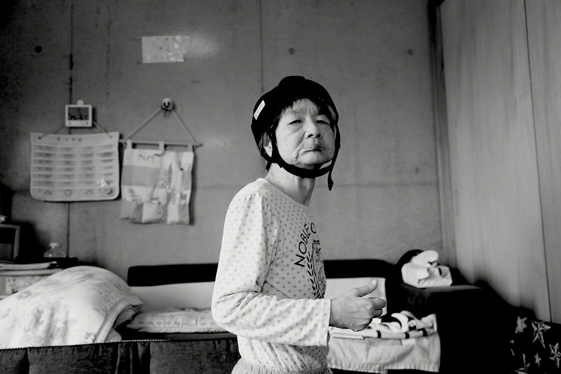 Tanaka Jitsuko à l’âge de 47 ans. À l’heure actuelle, elle vit chez sa  sœur ainée et son beau-frère. Elle doit faire l’objet de soins spécialisés 24h/24. Et si elle porte un casque, c’est pour éviter de se blesser la tête en tombant. (Photo prise en 2018)