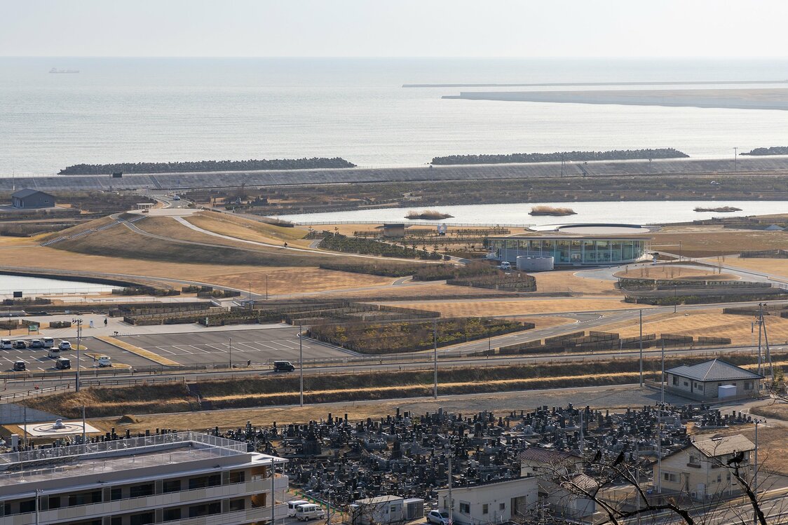 日和山公園から石巻南浜津波復興祈念公園を見下ろす。中央右の建物がみやぎ東日本大震災津波伝承館で、左の高台が一丁目の丘