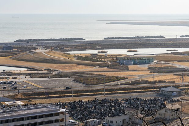 日和山公園から石巻南浜津波復興祈念公園を見下ろす。中央右の建物がみやぎ東日本大震災津波伝承館で、左の高台が一丁目の丘