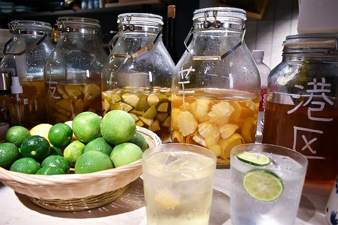 Sudachi y kabosu en licor. El vaso de la izquierda contiene un cóctel de sudachi, mientras que el de la derecha es de kabosu (imagen de nippon.com con la colaboración de Tsukanto Toranomon Hills).