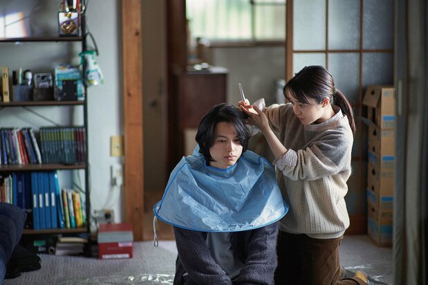 Fujisawa Misa cutting Yamazoe Takatoshi’s hair at his house. Visits to the barber are a constant source of stress for someone suffering from anxiety disorders. (© Seo Maiko/2024 All the Long Nights Production Committee)