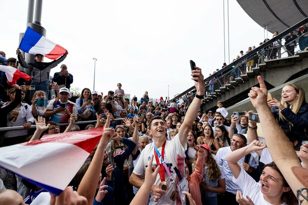 Diariamente, las competiciones estaban repletas de espectadores. En algunas de las sedes de atletismo, incluso se superó el número de personas que asistieron a las competiciones olímpicas. En la fotografía se observa a un medallista francés que se acerca a su familia, que se encontraba entre el público, para celebrar su triunfo y es rodeado por los espectadores que le solicitaban fotografías y coreaba Les Champs-Élysées. Fotografía de Ochi Takao.