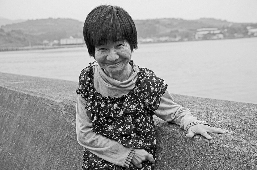 Sakamoto Shinobu 37 ans plus tard, devant la digue située en face de sa maison. (Photo prise en 2009)