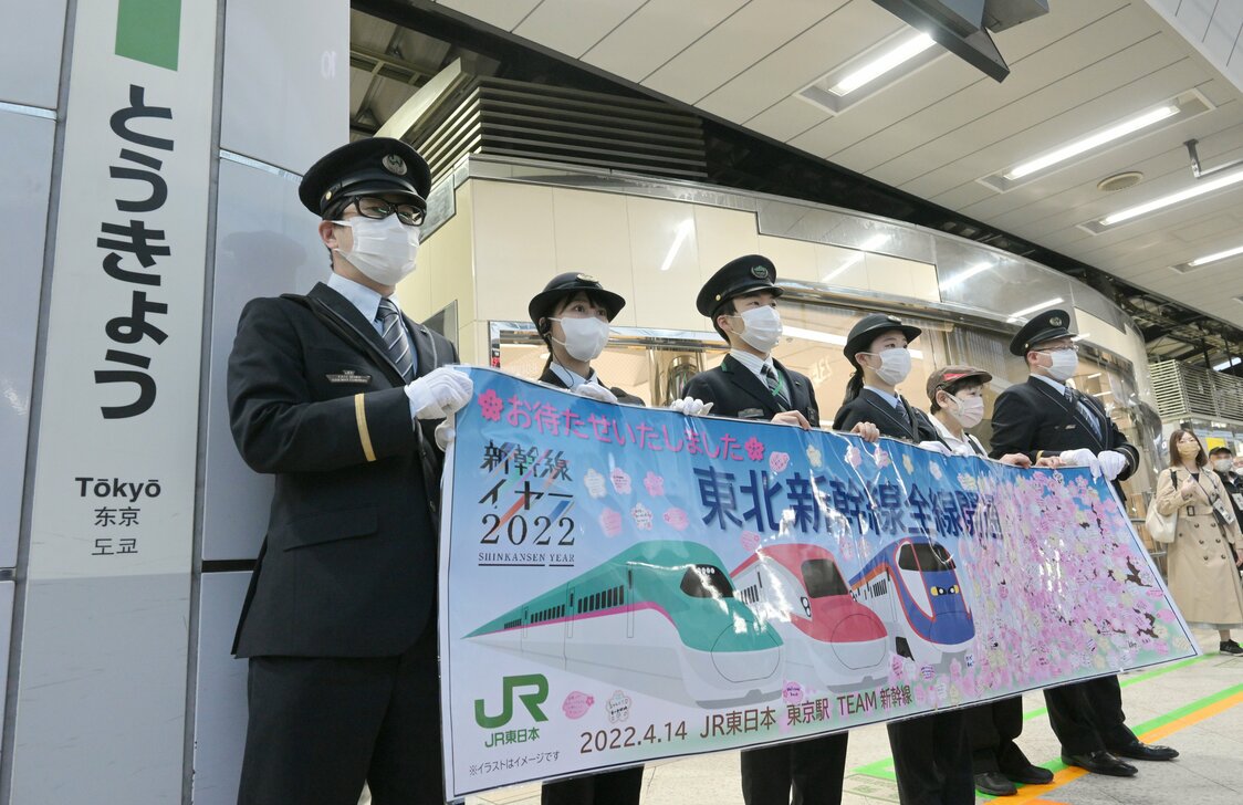 Trabajadores de JR East sujetan una pancarta que anuncia la reanudación completa de los servicios del Tōhoku Shinkansen el 14 de abril de 2022. (© Jiji)