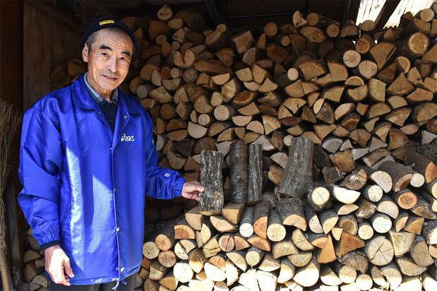 山から切り出した薪を手にする前川さん