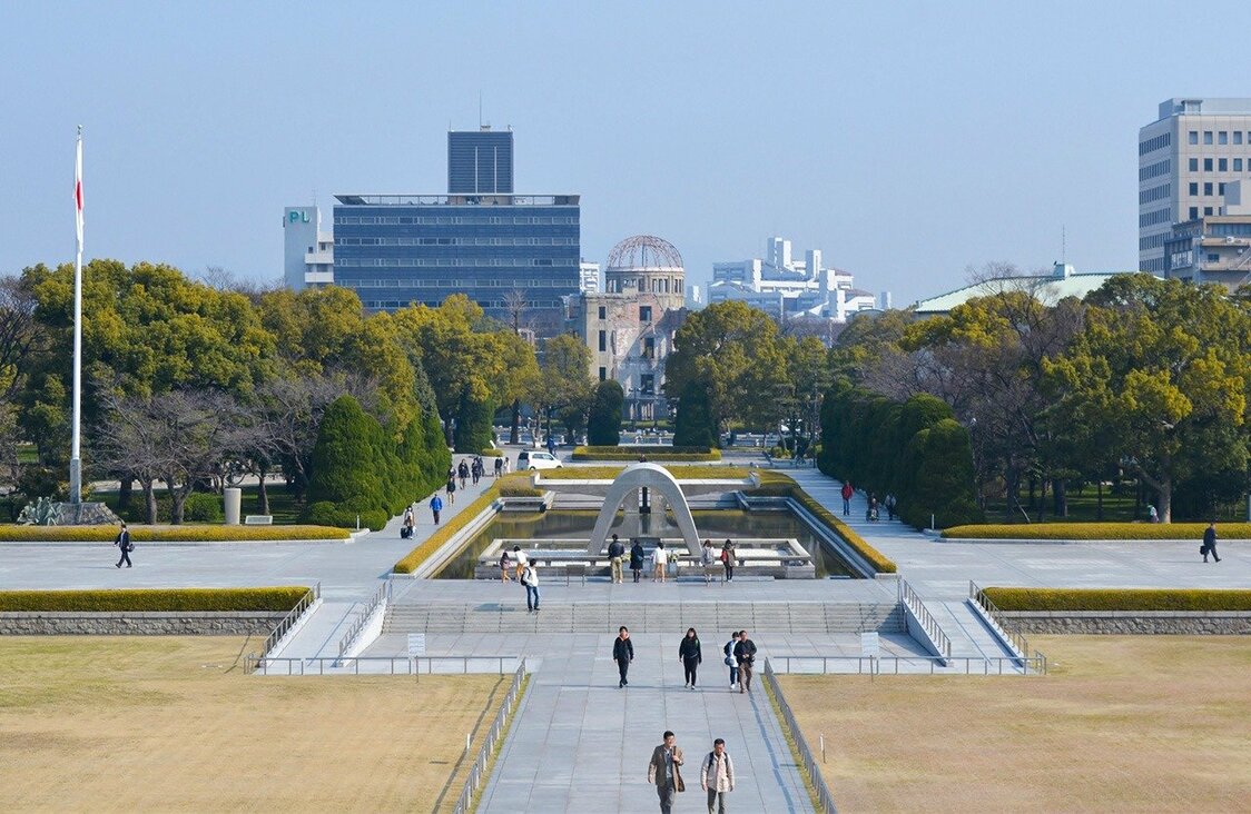 広島平和記念公園の原爆死没者慰霊碑（手前）と原爆ドーム