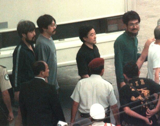 救出直後に安堵した表情を見せる日本人人質たち。中央の黒いシャツの男性が小倉氏=97年4月22日、ペルー・リマ(時事)