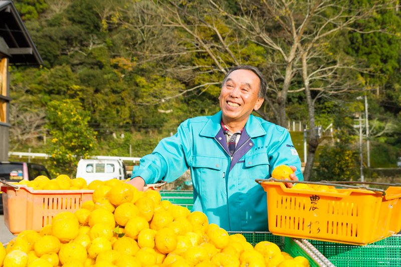 Tōtani Mochifumi, presidente de la Cooperativa Agrícola de Umaji, posa con una cosecha de yuzu.