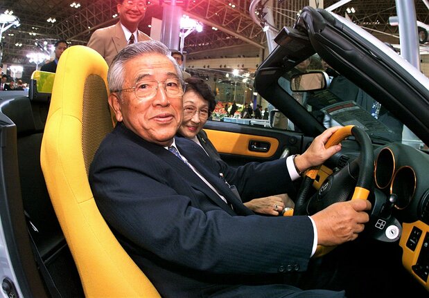 1999年10月の東京モーターショー、トヨタMR-Sの運転席でステアリングを握る豊田章一郎氏 AFP=時事