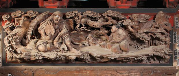 El tengu y Ushiwakamaru, flanqueados por dragones voladores. El fondo es muy delicado y el veteado de la madera muy hermoso. Ihachi también es un maestro tallando figuras. (Cortesía de Ihachi-kai, fotografía de Odajima Nobuyuki)
