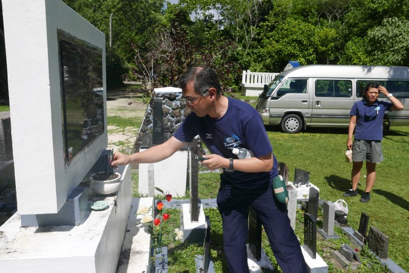 Un visiteur japonais déposant des bâtonnets d’encens sur le monument aux morts de Peleliu.