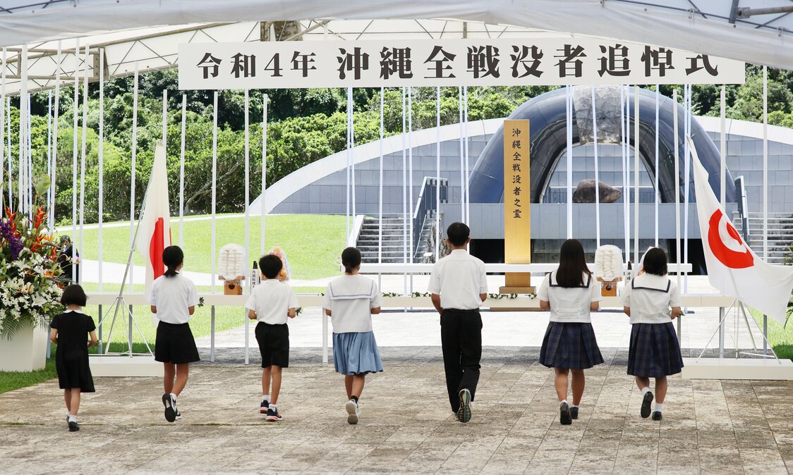 Niños se acercan al altar para hacer una ofrenda floral en la ceremonia del Día Conmemorativo de Okinawa del 23 de junio, en el Parque Conmemorativo de la Paz de Itoman, Okinawa. (© Jiji)
