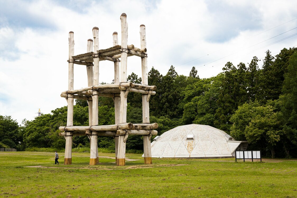 A reconstruction of the pillar-supported building stands next to the original site of the structure.