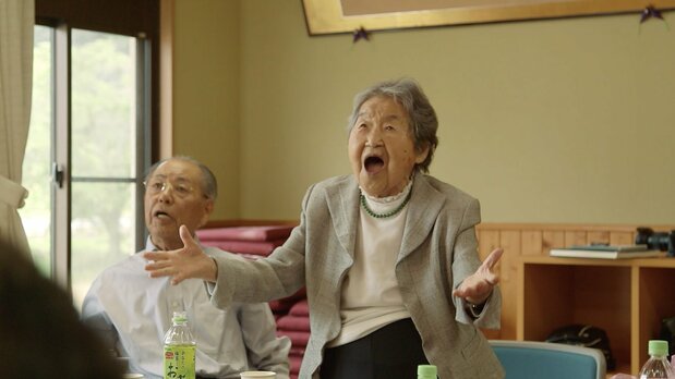 Tetsuyo canta junto a sus antiguos alumnos durante una fiesta de reunión. (© Comité de producción de 104 sai, Tetsuyo san no hitori gurashi)
