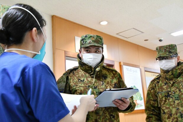 陆上自卫队的护士（左）在被派遣地庆友会吉田医院（北海道旭川市）与自卫队员商量医疗支援事宜，防卫省统合幕僚监部提供（时事社）