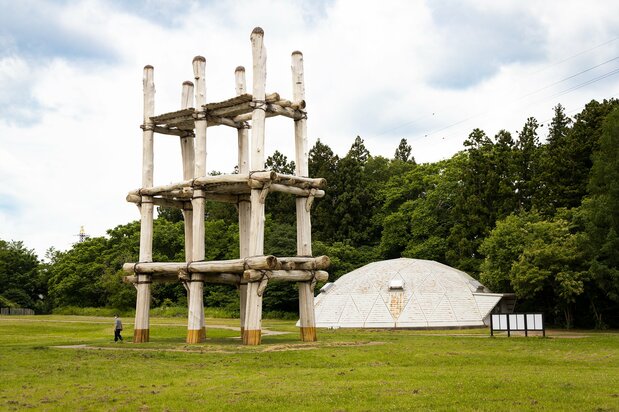 A reconstruction of the pillar-supported building stands next to the original site of the structure.