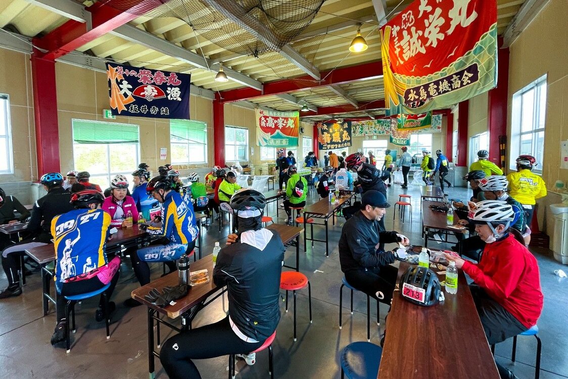エイドステーションで補給食を取るサイクリスト（サイクルツーリズム研究会提供）