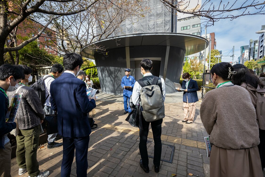 初開催のバスツアーは、安藤忠雄氏設計の「神宮通公園トイレ（あまやどり）」から出発した