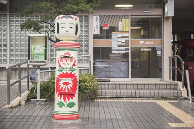 郵便局の前に設置された、こけしをモチーフにしたポスト　写真：シュープレス