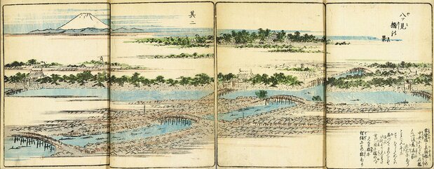 広重『絵本江戸土産』の「八ツ見橋の景」は2つの見開きにわたっているので、つなげてみた。そこには江戸橋の北東上空から見えたであろう、美しいパノラマが描かれている。右下には、一石橋の名の由来について書かれている 国会図書館所蔵