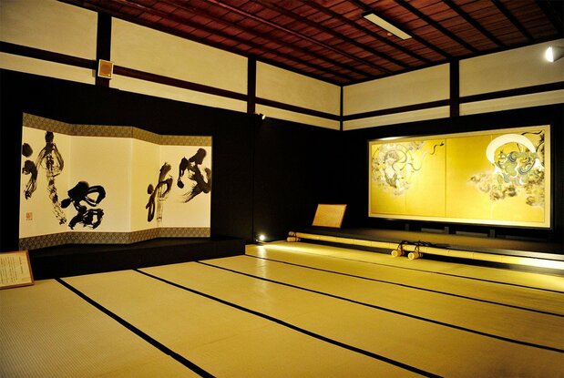 Caligrafía de Fūjin Raijin (dioses del viento y el rayo) junto a un biombo, Tesoro Nacional, de la misma temática en el templo Kenninji, en Kioto. (Imagen por cortesía del templo Daihonzan Kenninji)