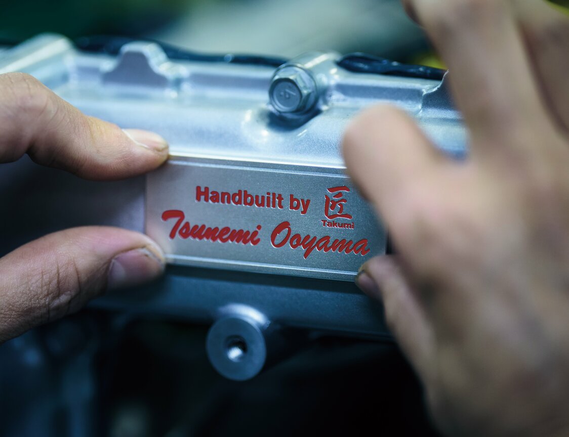 Each R35 GT-R engine is hand-assembled by nine master craftspeople, with the name of the person in charge of the team engraved on a plate affixed to the engine. (Courtesy Nissan Motor)