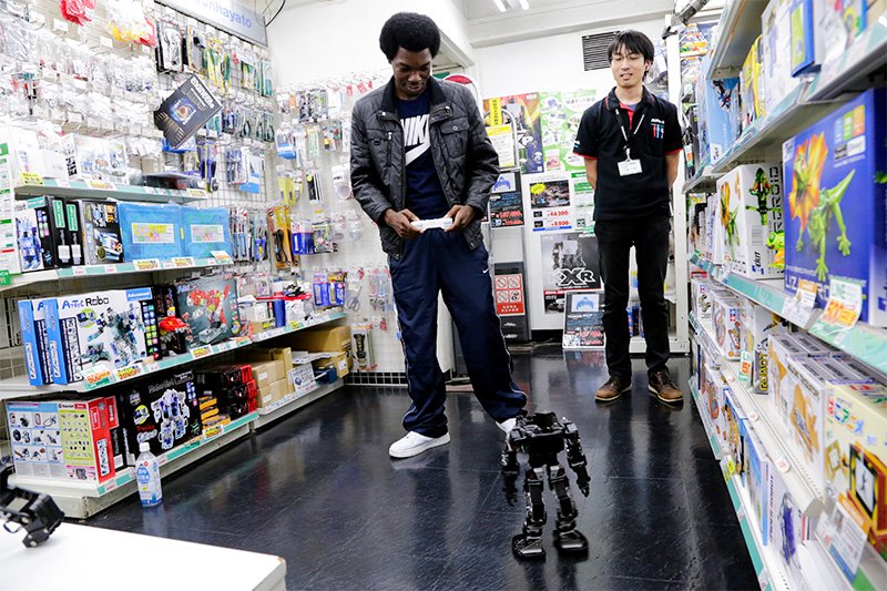秋葉原のロボットショップで、リモコンロボットのリズミカルな動きに歓声を上げる