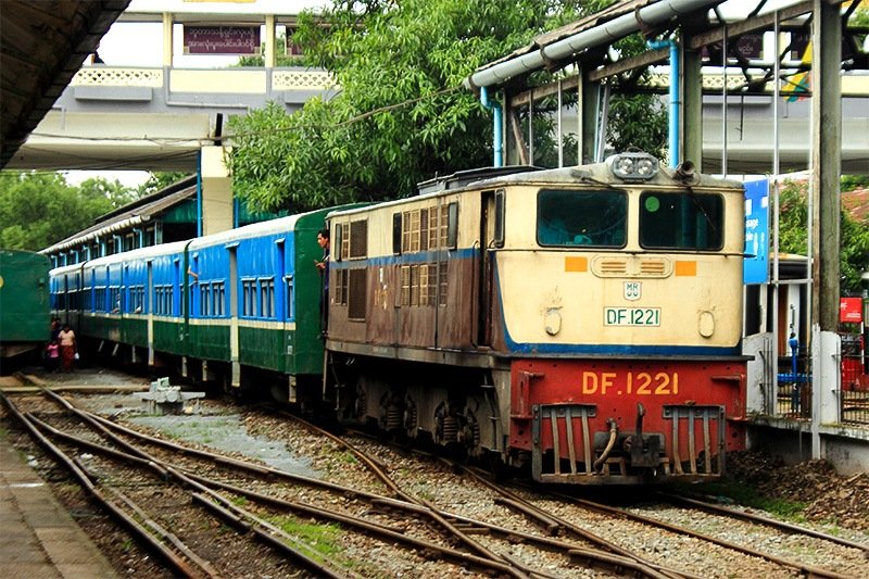 Passenger carriages pulled by a battered locomotive.