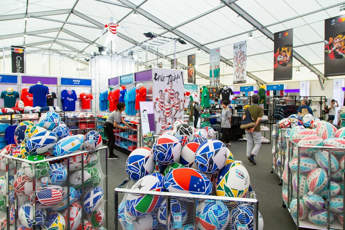 カラフルなグッズが並ぶ巨大な店内。出場国の国旗と大会ロゴをあしらった「フラッグボール」は人気商品