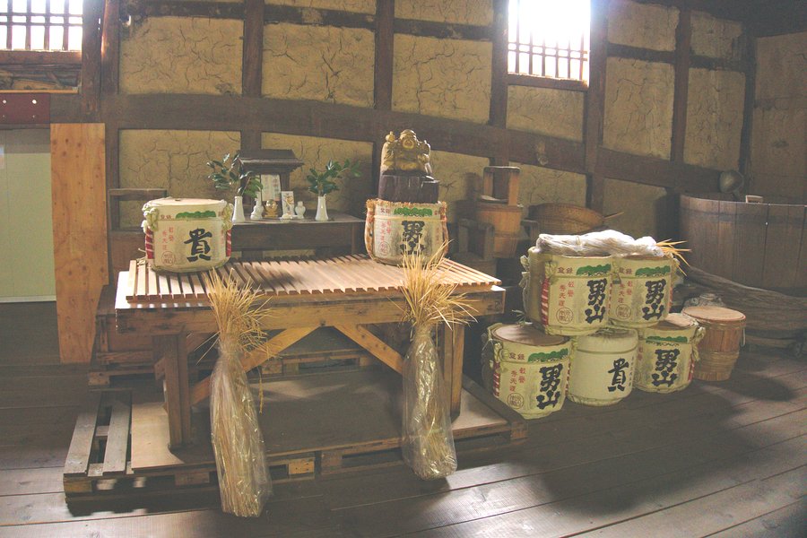 Casks of sake are placed with sheaves of locally harvested rice before the brewery’s altar.