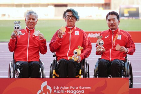 Tomoki Sato (center) earns gold, Tomoya Ito (left) silver and Tatsuya Ito (right) bronze in a wheelchair 400-meter sprint event for men at the Aichi-Nagoya Asian Para Games on Thursday.