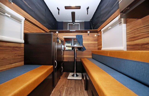 The interior is decorated with wood tones and has bed space for three adults. (© Iwata Kazunari)
