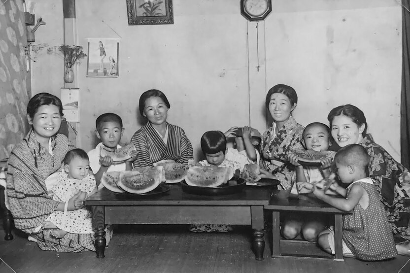 Cette photo, prise au studio photo Takahashi en été 1936, nous montre la famille Takahashi tout sourire, en pleine dégustation de pastèque. Hisashi est le petit garçon se cachant la face avec un morceau de pastèque. (Avec l’aimable autorisation de Takahashi Hisashi)