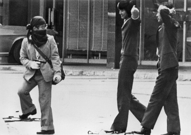 7 de agosto de 1975: un miembro del Ejército Rojo Japonés, arma en mano, conduce a unos rehenes a un autobús que se dirige al aeropuerto. Cinco miembros de la organización atacaron las embajadas de Estados Unidos y Suecia en Kuala Lumpur y exigieron la liberación de los extremistas que se hallaban bajo custodia en Japón. Los criminales se exiliaron a Libia, llevándose a los rehenes consigo. (Jiji Press)