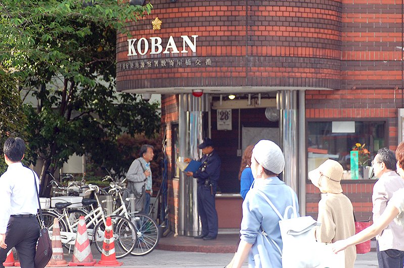Un transeúnte pregunta a un agente en el kōban del cruce de Sukiyabashi.