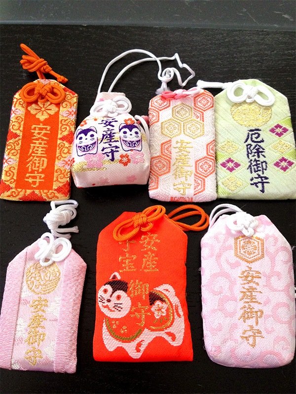 Plusieurs omamori avec différents motifs et couleurs. Ceux sur la photo permettraient un accouchement sans complications (photo : Pixta)