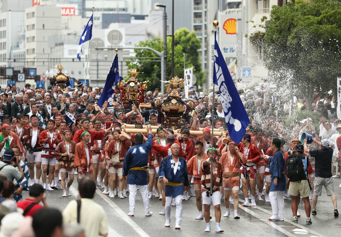 2017年の深川八幡祭り「連合渡御」。見物客が担ぎ手たちにバケツの水を浴びせる　時事