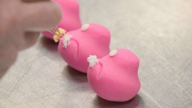 Les artisans de wagashi hautement qualifiés attentifs au moindre détail, affairés à la confection des jônamagashi