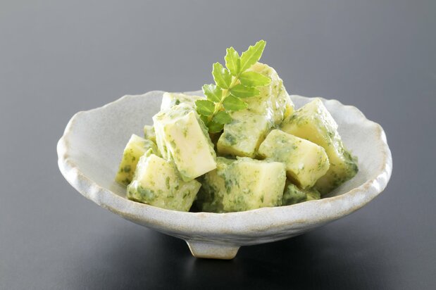 Jeune pousse de bambou nappée de miso blanc et de sanshô moulu, et garnie de jeunes feuilles de sanshô. (© Pixta)