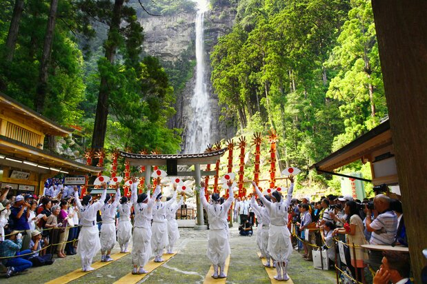 水潭边,12顶形似瀑布、高6米的细长型红色“扇神舆”列队而立