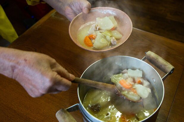 Nagayama serves up his hyakusai nabe, a miso-seasoned stew of vegetables and chicken. The breast meat of chicken is rich in carnosine, an antioxidant that can slow down the aging process. (© Ōnishi Naruaki)