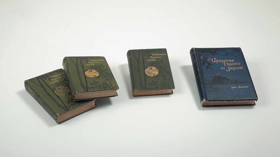A la izquierda, tres versiones diferentes de Unbeaten Tracks in Japan, de Bird. Desde la izquierda: la edición original en dos volúmenes, publicada en 1880, la edición abreviada de 1885, y la nueva edición publicada en 1900, a la que se añadieron 14 fotografías.