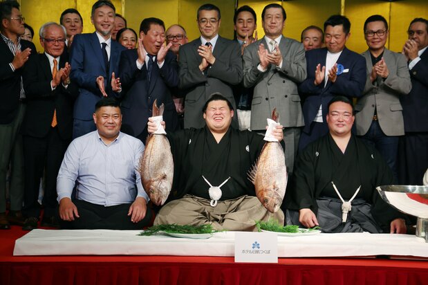 大之里夺得夏季赛事冠军,手举鲷鱼庆祝。右边是师傅、原横纲稀势之里。茨城县筑波市(时事社)