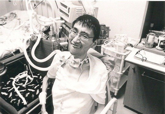 Shikano connected to a mechanical ventilator following a tracheotomy operation in 1995. (© Takahashi Masayuki)