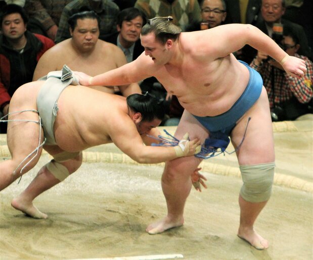 相手の肩越しにまわしを取り、吊り上げるようにして投げる「大逆手」。つかんだ腕の方向(逆手)に投げる珍しい技で、2010年初場所14日目、エストニア出身の関脇・把瑠都(右)が垣添を相手に決めた。時事