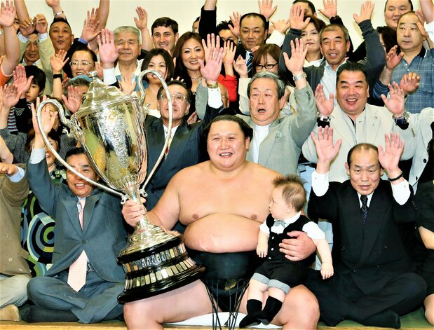Mongolia-born Kyokutenhō, then a seventh-ranked maegashira, celebrates at the Ryōgoku Kokugikan in Tokyo on May 20, 2012, after winning the summer basho, setting an age record that Tamawashi would break a decade later. (© Jiji)