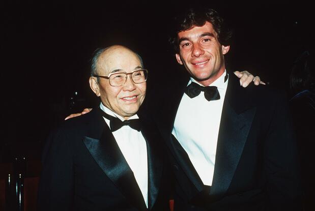 パリで開催されたパーティーに出席し、肩を組むマクラーレン・ホンダのアイルトン・セナ(右)と本田宗一郎本田技研最高顧問=1990年12月(AFP=時事)